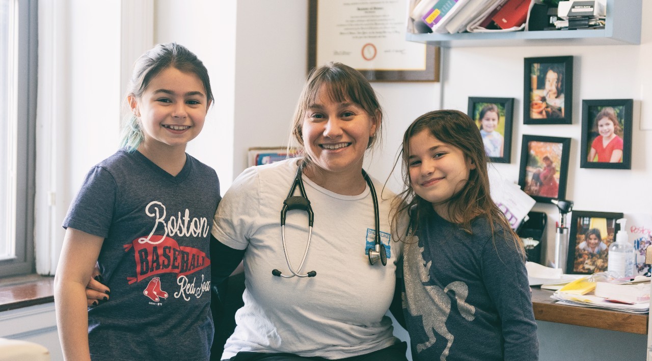 pediatrician with a child on either side of her