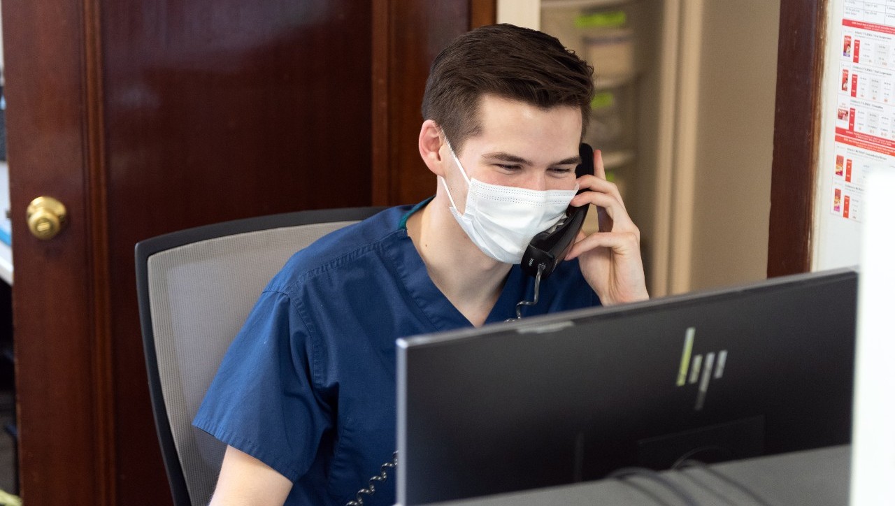 a male nurse wearing a mask and talking on the phone
