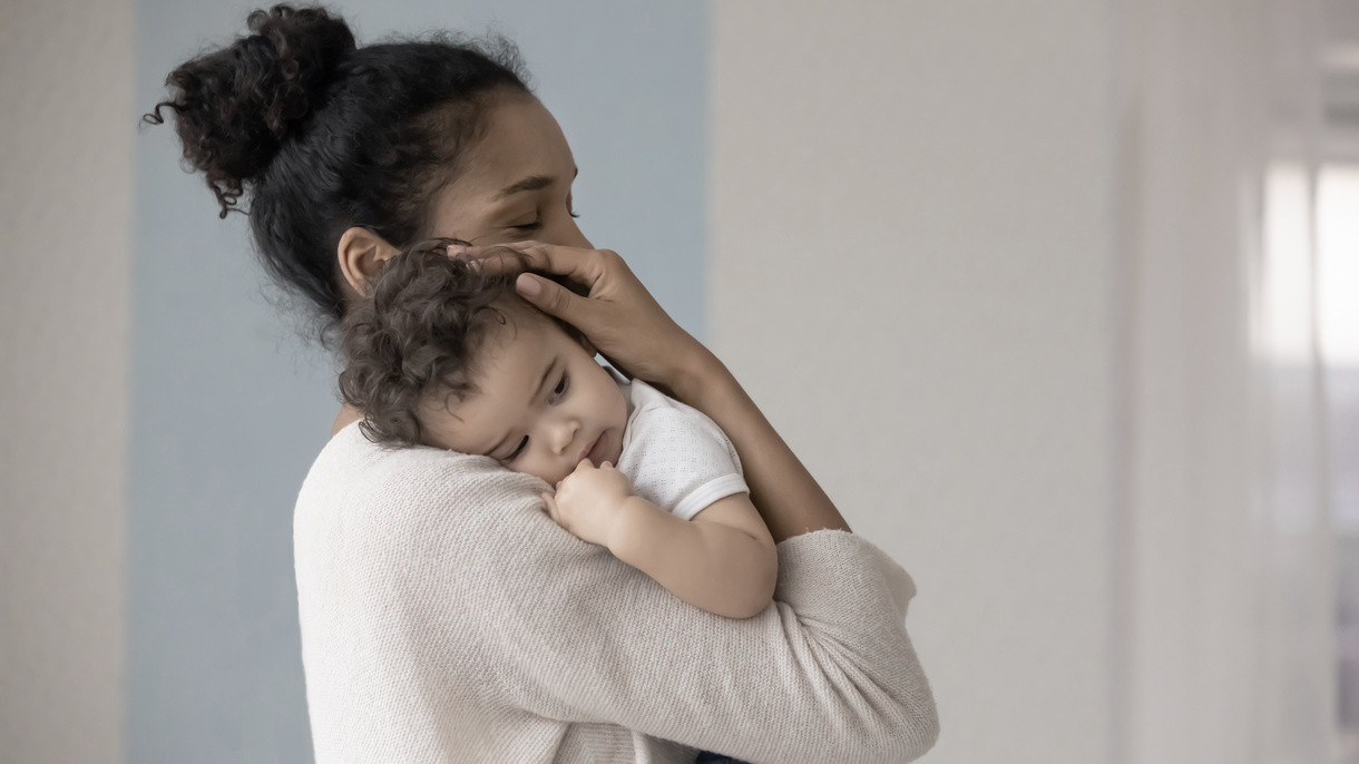 mother cradling her baby against her shoulder