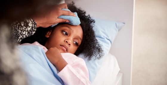 Parent holds rag to child's forehead