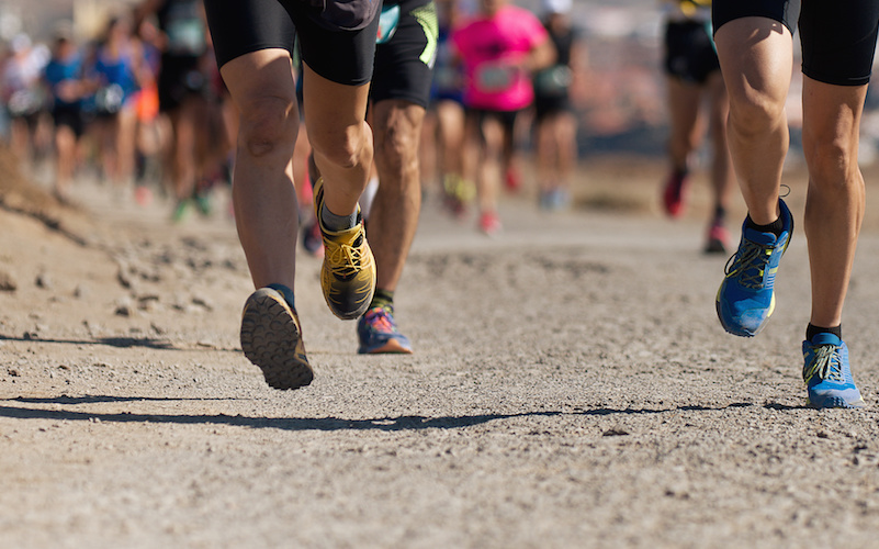 Feet make contact with ground as runners head down trail