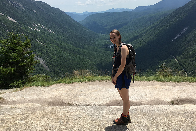 Girl stands amidst mountains