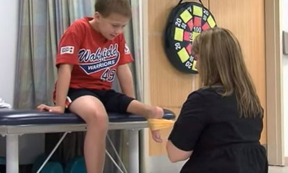 clinician helping boy learn to use the rotated limb