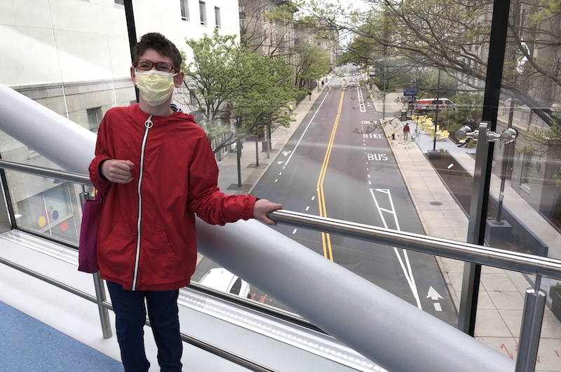Boy stands on skybridge at Boston Children's Hospital campus