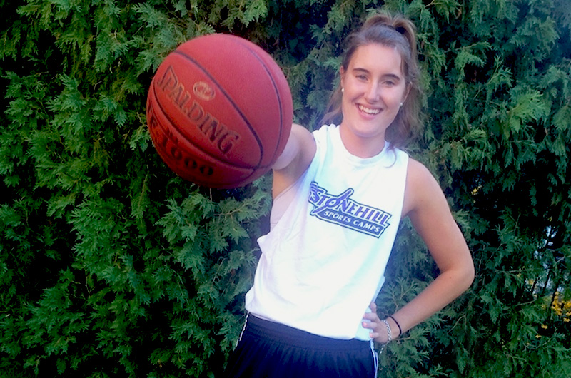 Teen girl holds out basketball