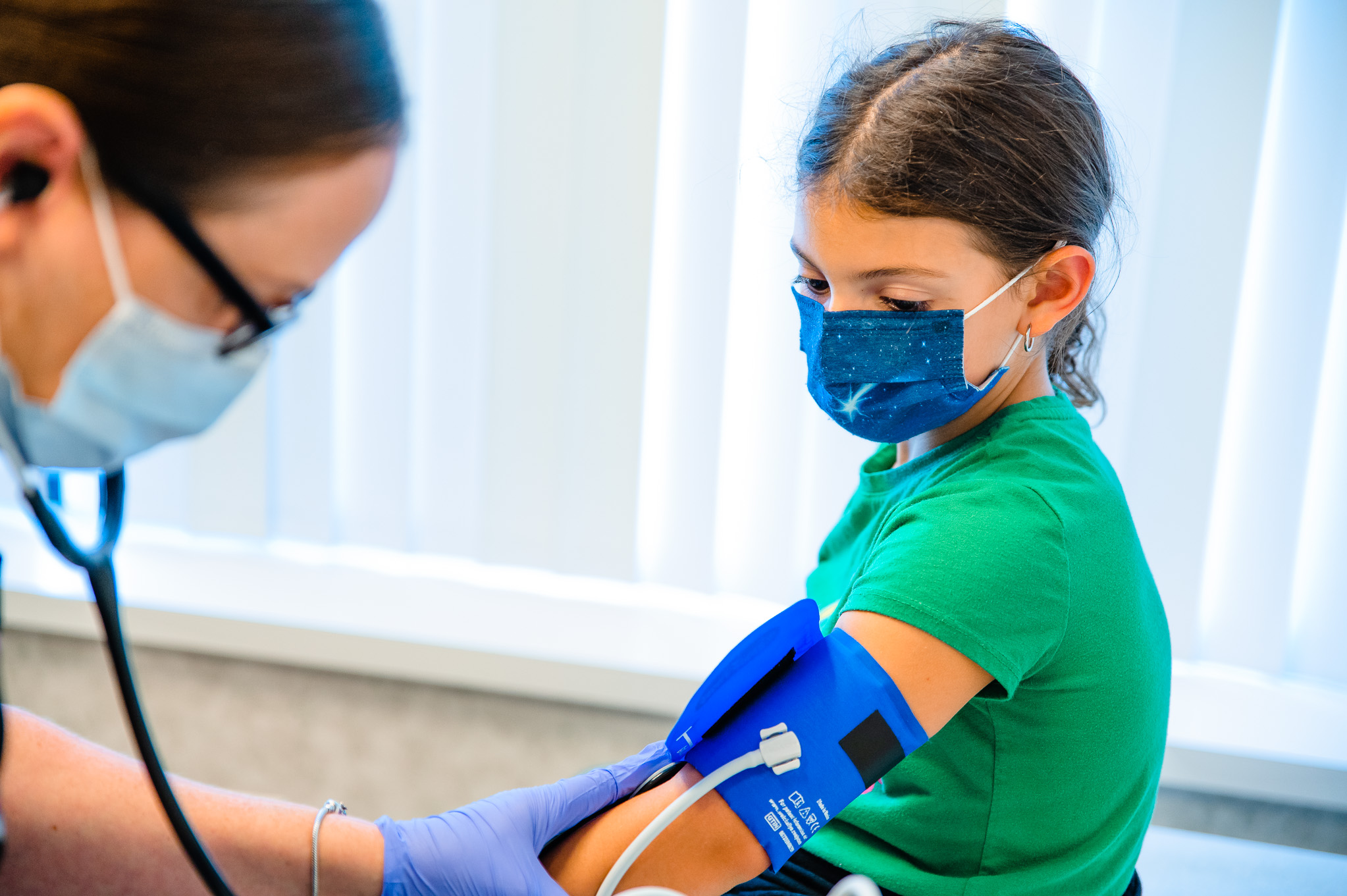 Clinician checks girl's blood pressure