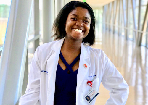 Louise, former patient, stands on SkyWalk wearing white coat