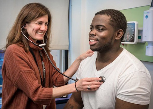 Clinician holds stethoscope to Manny's chest