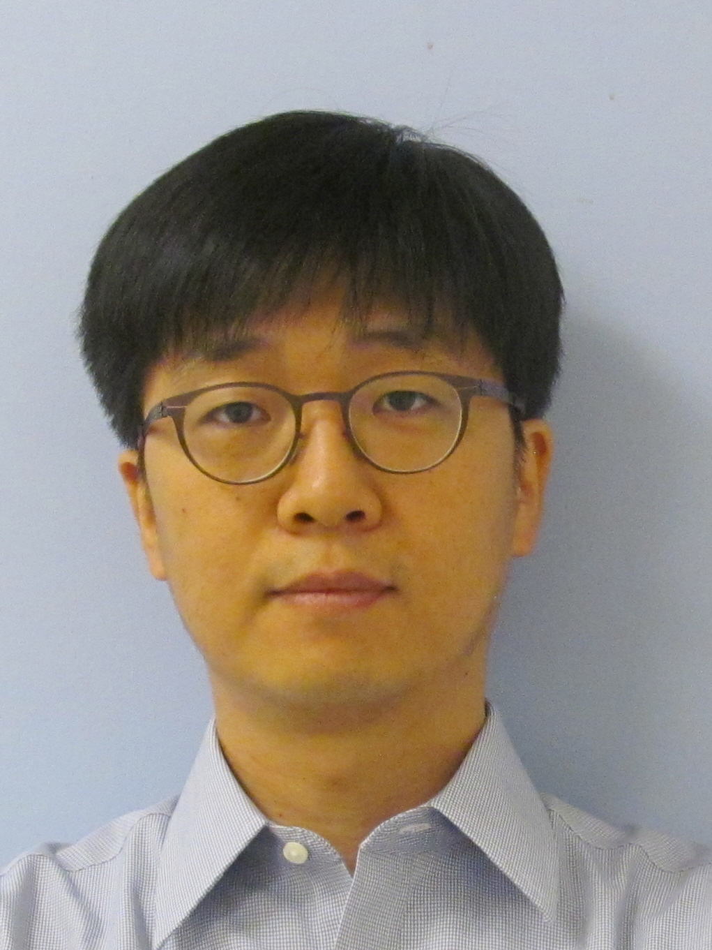 Headshot of Dongwon Lee, a man with short dark hair cut in a bowl cut, wears glasses and looks at the camera with a serious expression.