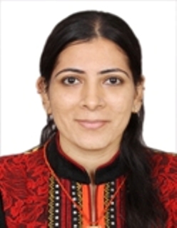 Headshot of Neha Nagpal, a woman with long dark hair gives the camera a close-lipped smile.