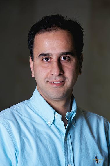 Headshot of Mehdi Pirouz, a man with dark hair wears a blue shirt and smiles at the camera.