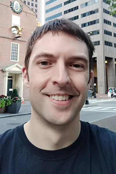 Headshot of Kurt Whittemore, a man with short brown hair who stands outside in Boston and smiles at the camera.