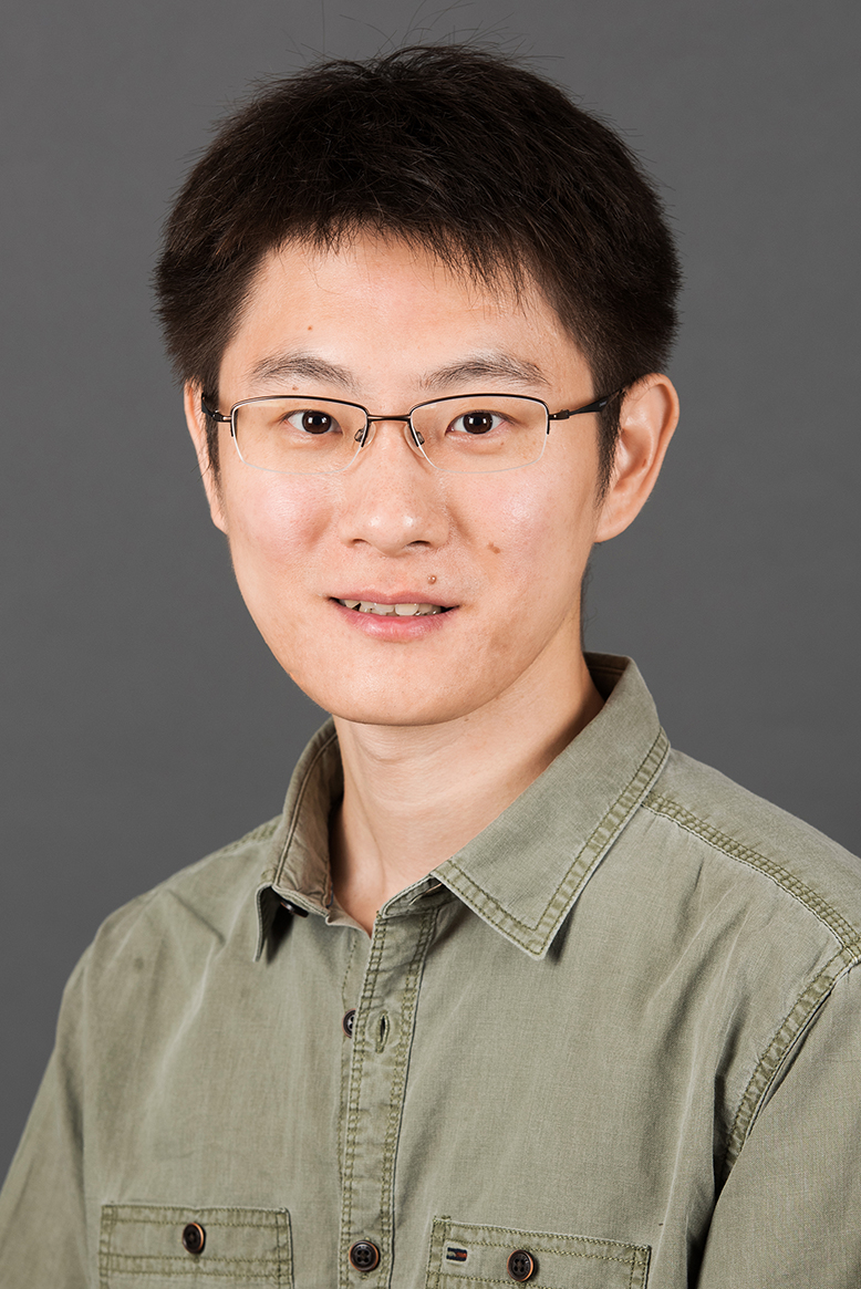 Headshot of Boxun Zhao, an asian man with square glasses wears a green shirt and smiles at the camera.