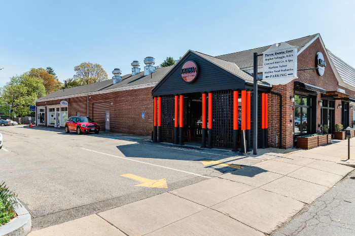exterior of brick building with a dark black and red entrance on the side