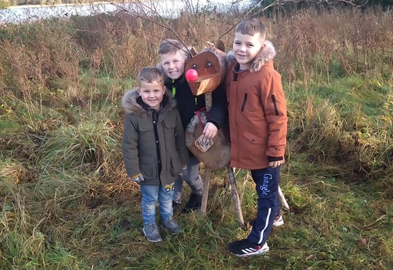 Brothers have arms around each other while standing in field.