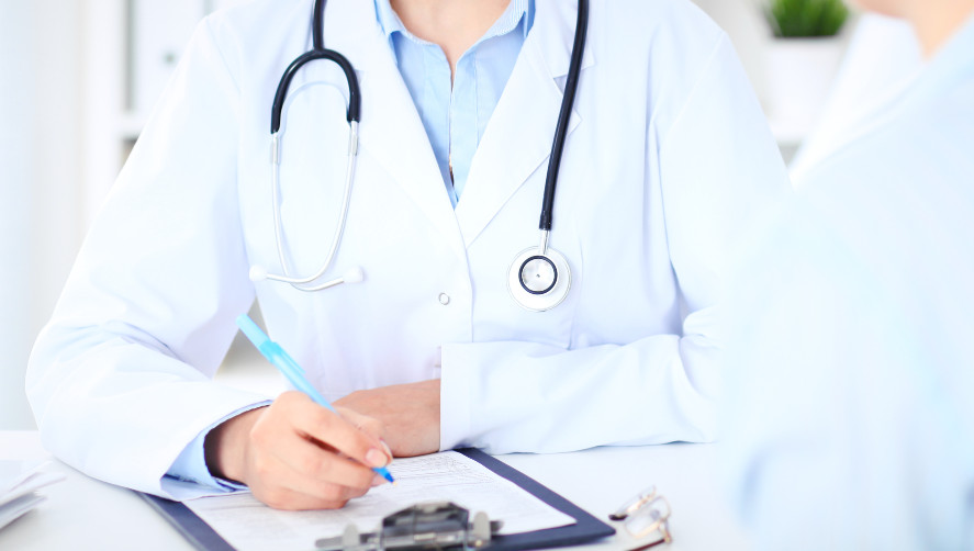 the body of a medical person filling out a form