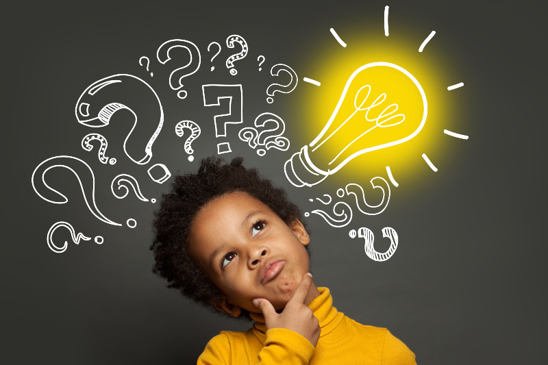 a boy thinking with illustrations on a blackboard behind him