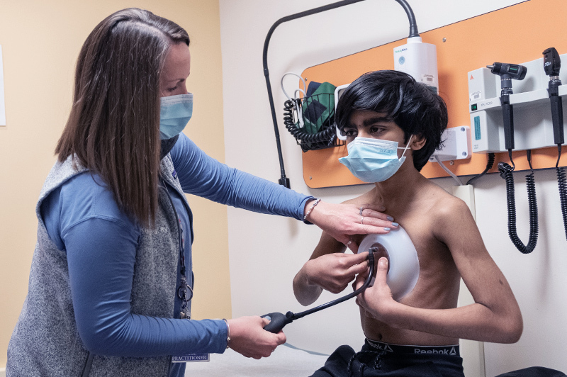 Clinician examines boy's chest condition