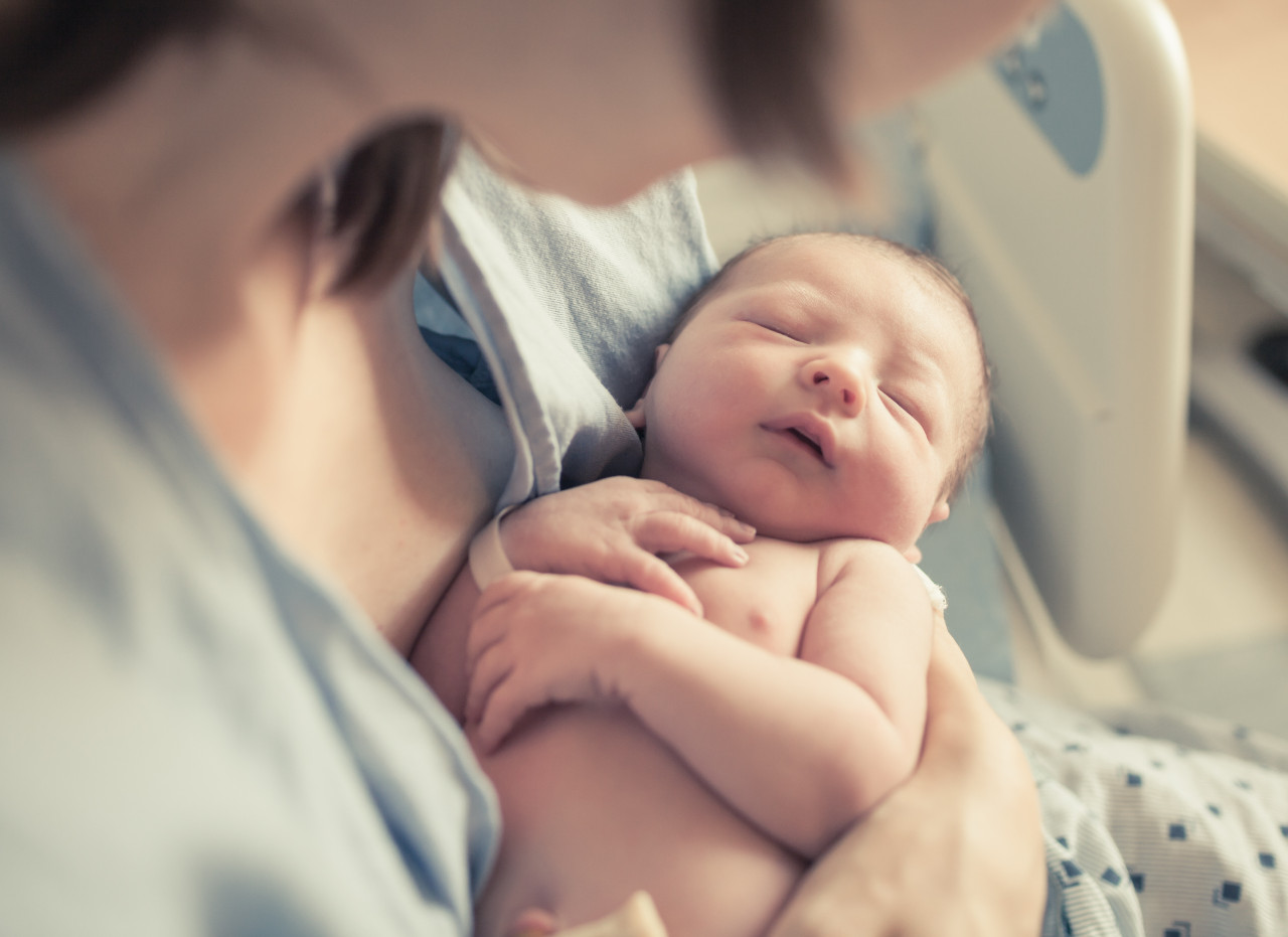 a newborn baby in the arms of a mother