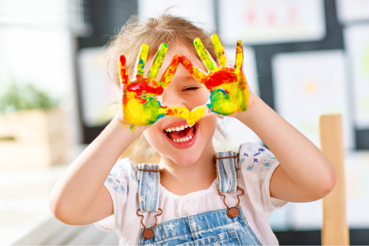 a girl with colorful paint on her hands