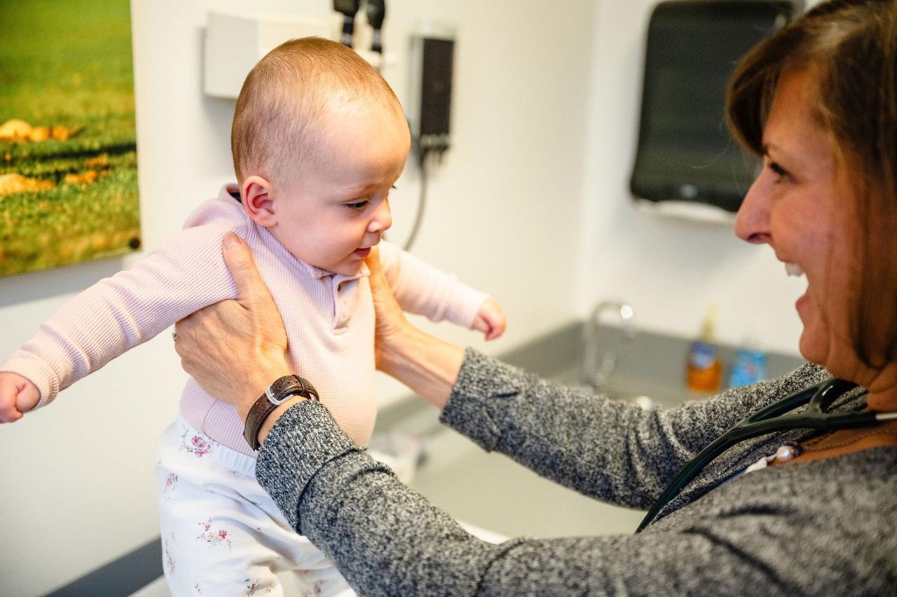 a child being held by a pediatrician
