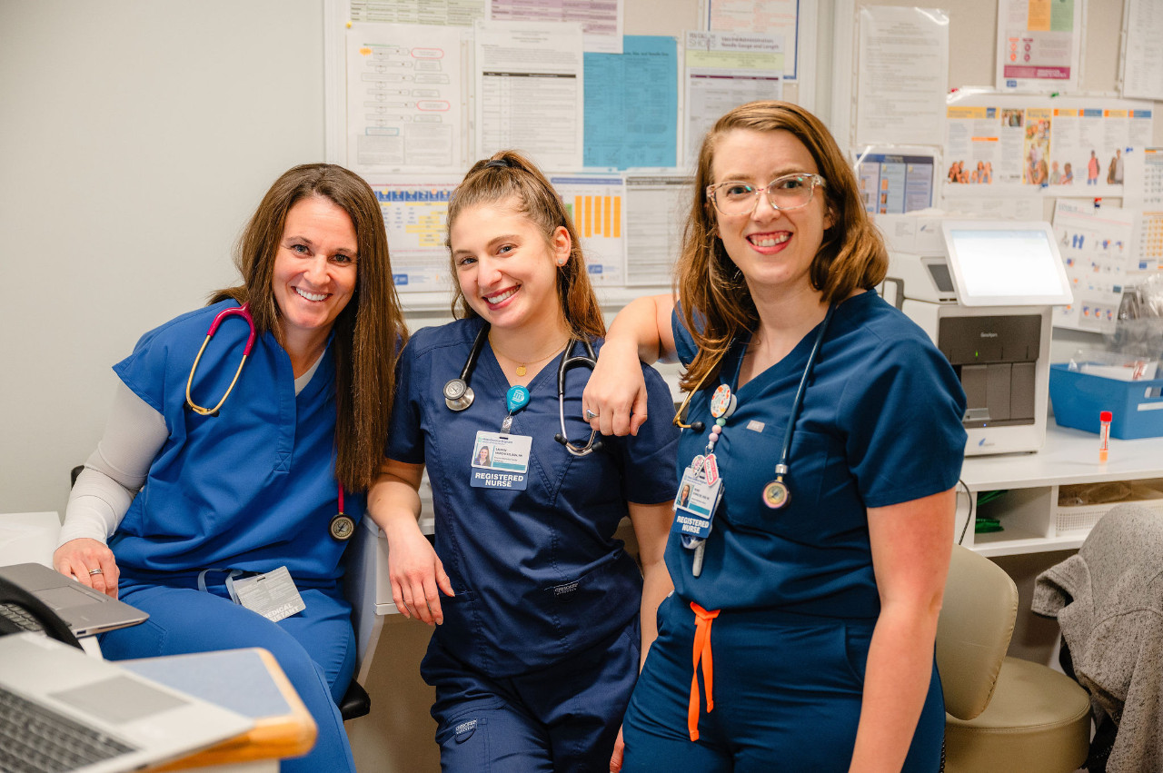 three female nurses in scrubs smiling