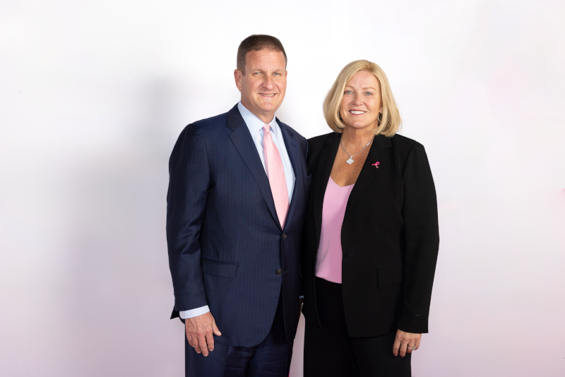 Man wearing suit and tie and woman wearing business suit pose for portrait
