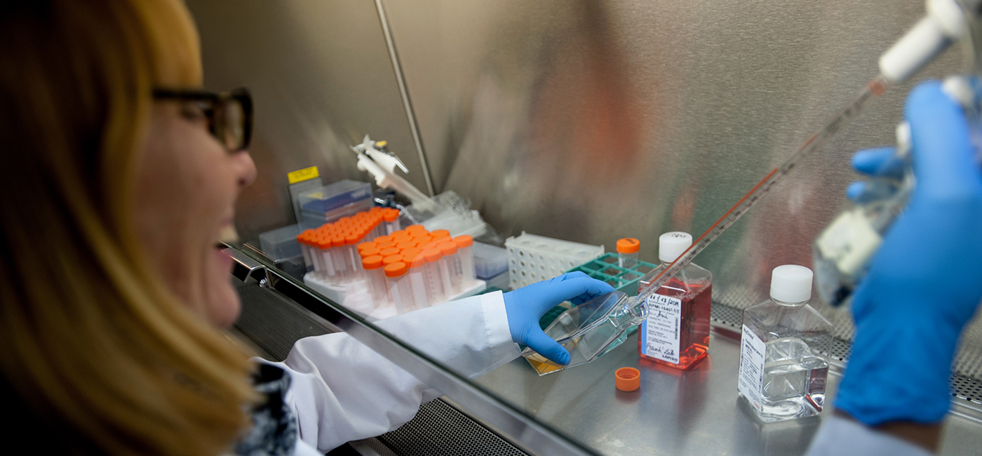 Researcher uses syringe to put substance into vial