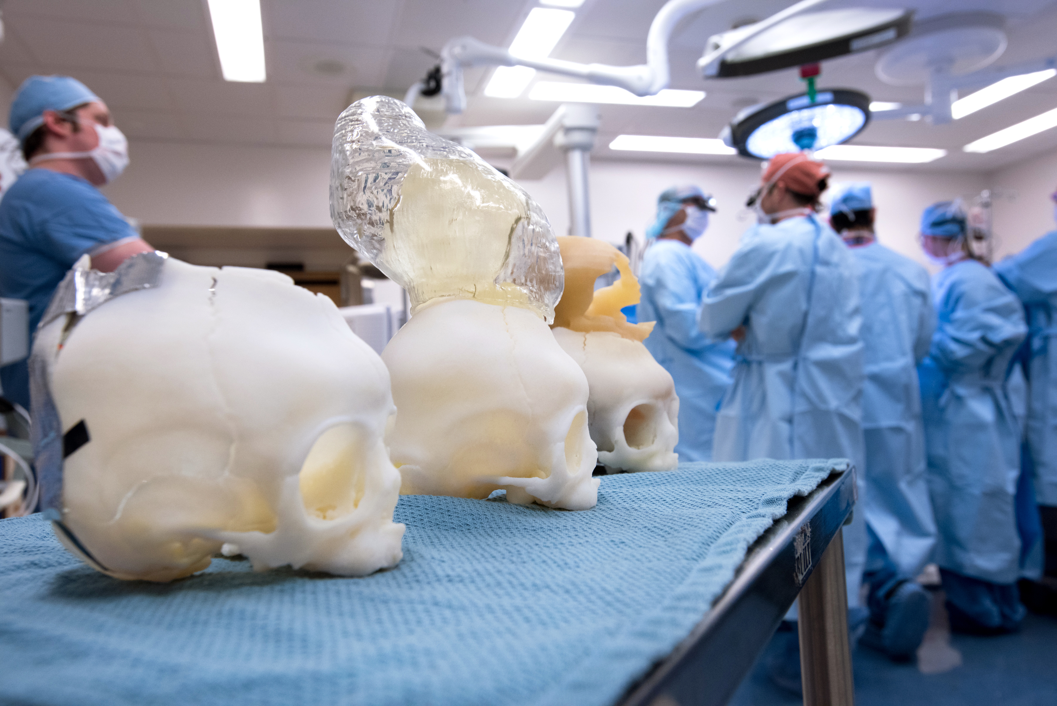 Partial plastic skulls sit on table in operating room