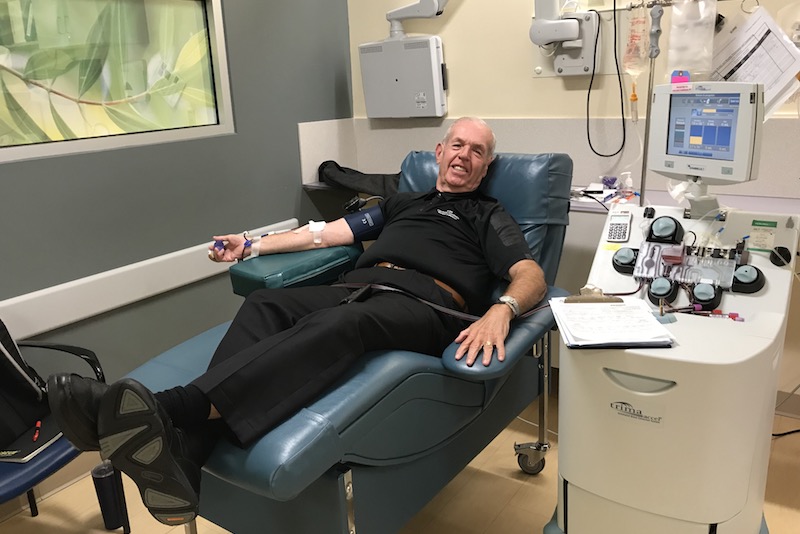 Older man sits on comfortable chair in blood clinic while donating platelets