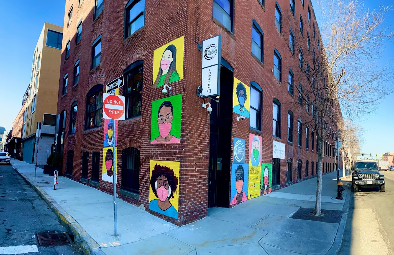 Exterior of brick buidling with small portraits painted on brick
