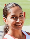 Headshot of Amy Dave, a woman with her hair in a ponytail stands outside and smiles at the camera.