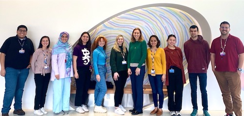 Three men and eight women in rainbow colored shirts.