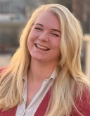 Headshot for Morgan Walcheck, a postdoc woman with blond hair laughs with her face to the sun.