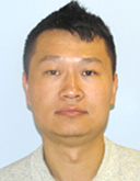 A man, Yuxiang Zhang, has short dark hair and a serious expression on his face as he looks at the camera for his headshot.