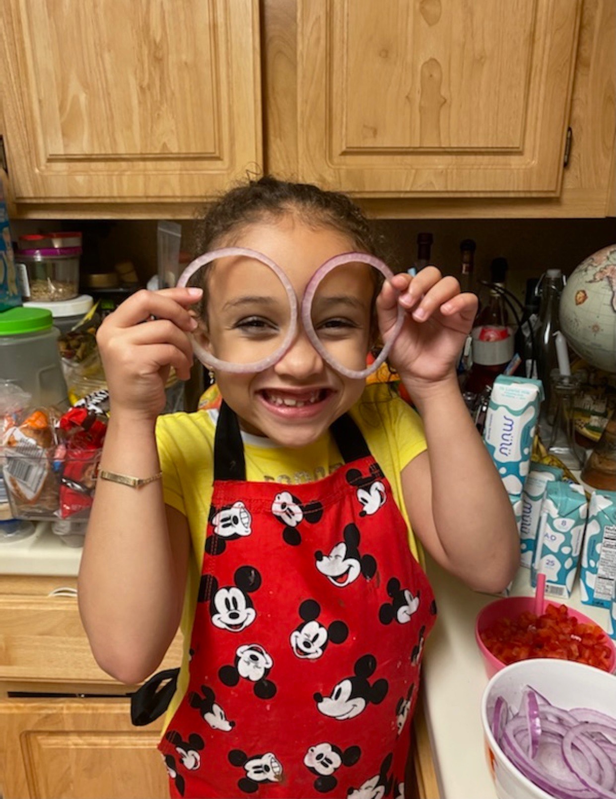 Girl holds pieces of sliced onion over her eyes