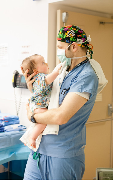 a doctor holding a baby in his arms