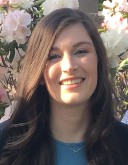 Elizabeth Molnar, a lab technician for the North Lab, stands outside and smiles at the camera for her headshot.