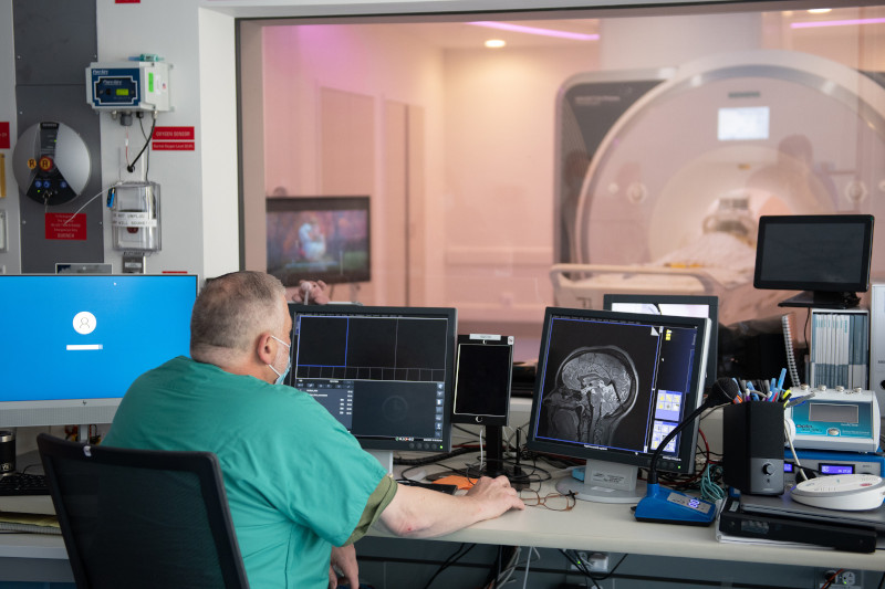 MRI tech surrounded by MRI machine and associated equipment