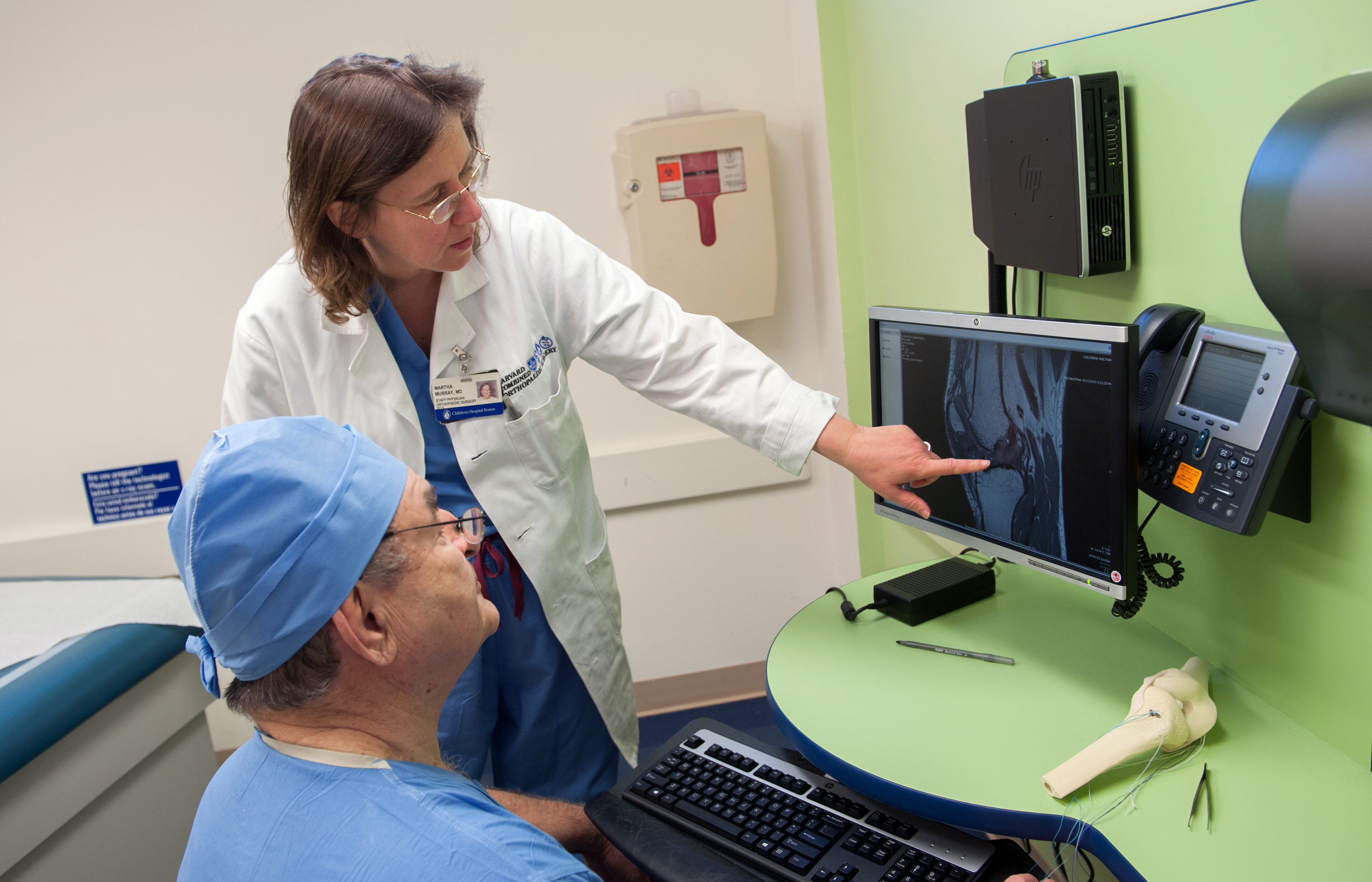 Drs. Martha Murray and Lyle Micheli look at imaging of a patient's knee.
