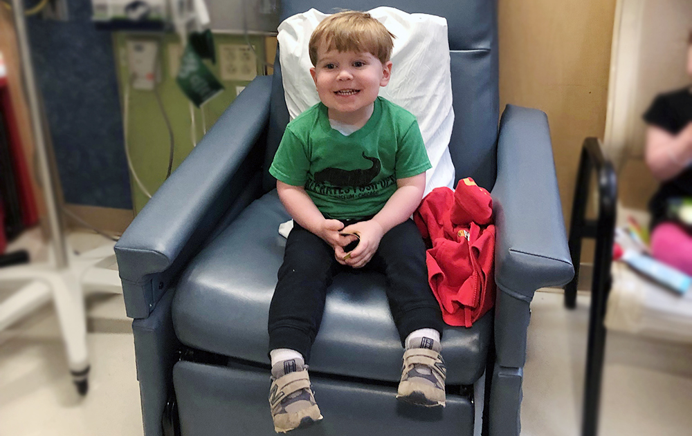 Boy sitting on a chair at the Boston Hemophilia Center.