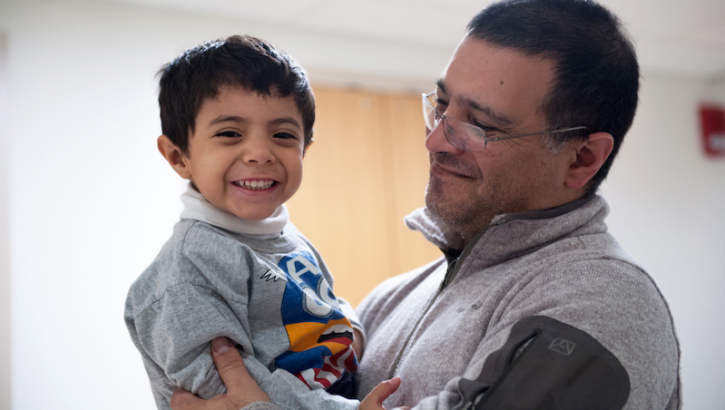 Father holding his son who had a stem cell transplant for SCID