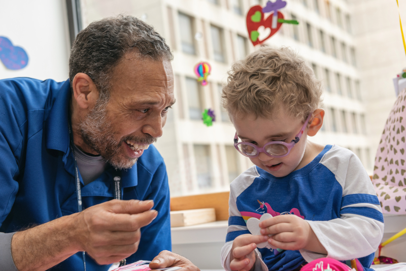 Lucilo Puello, winner of 2019 Boston Children's Hospital Best in Care Award, plays with a patient.