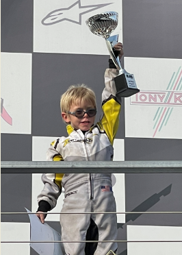Mikey holds trophy after auto race