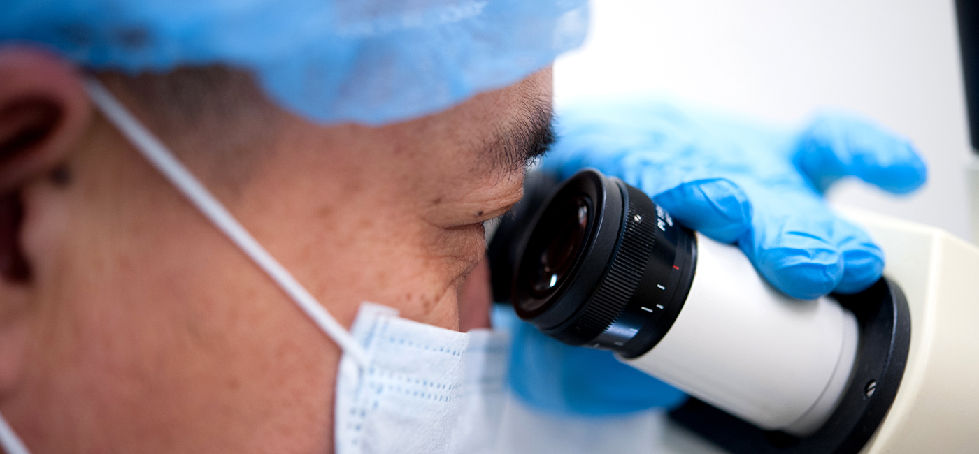 Lung-transplant researcher looking into microscope 