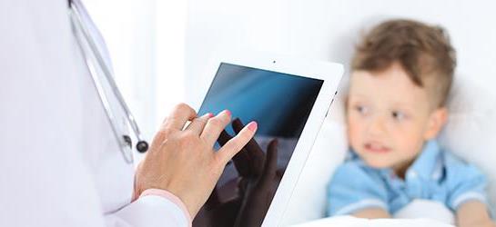 Female doctor using a digital tablet, close-up of hands. Health care concept or children's therapy.