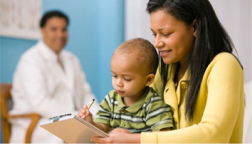 woman holding infant while filling out a form.