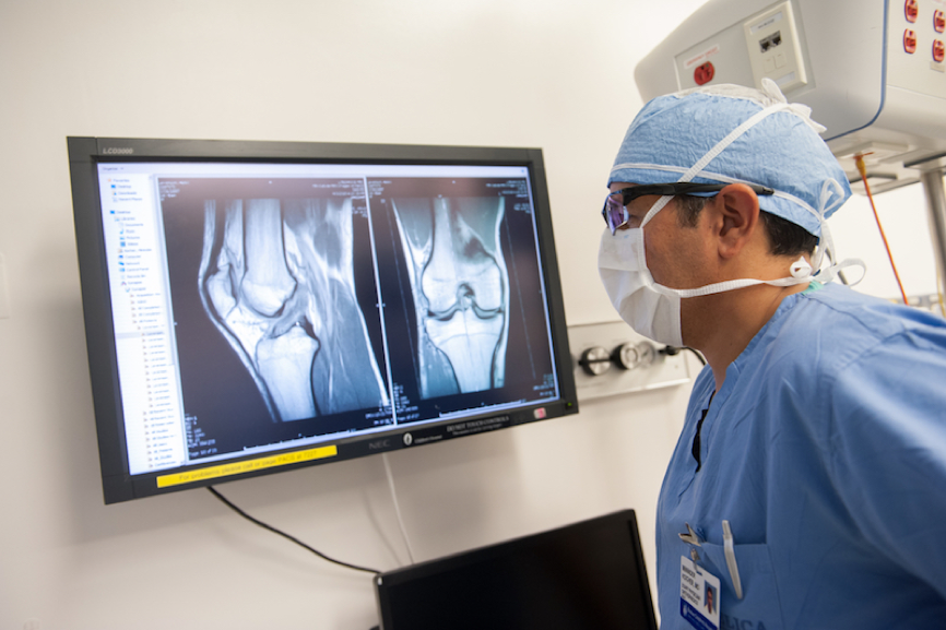 Mininder Kocher, MD, Chief of the Sports Medicine Division, examines an image of a patient's knee.