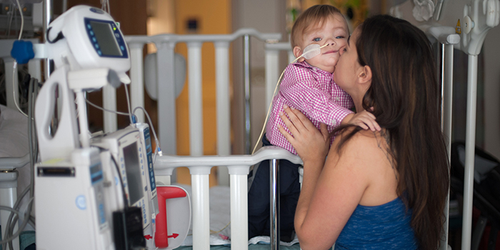 “Kidney transplant recipient Gavin, held by his mom in his hospital room
