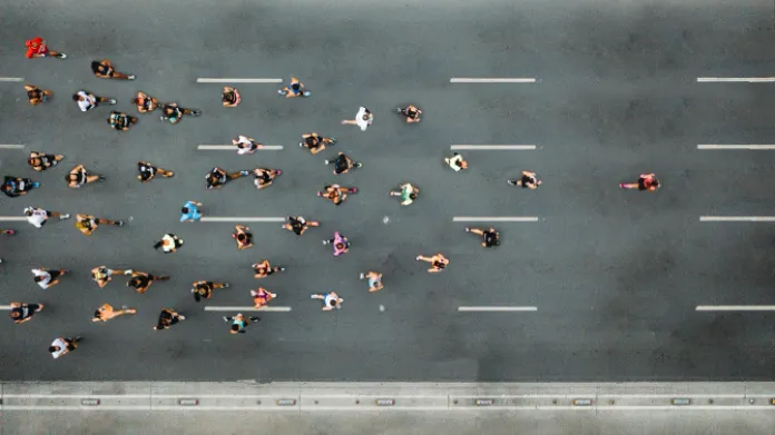 Aerial view of a large pack of runners moving down a wide, paved street